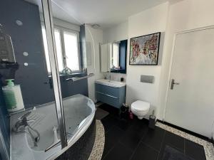a bathroom with a tub and a toilet and a sink at Entre Bourges et Sancerre Escale Bien-Être in Les Aix-dʼAngillon +24 photos