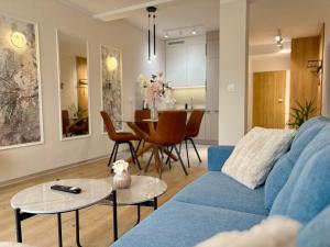 Una sala de estar con un sofá azul y una mesa. en Apartament Uroczy w Szczyrku na stoku, en Szczyrk 18 fotos más