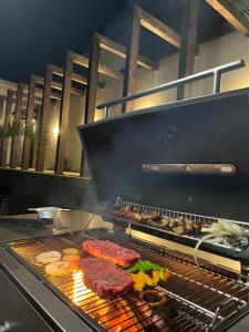 a grill with meat and other food on it at Onomichi Villa Ayah in Onomichi