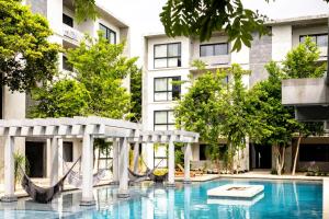 a swimming pool with a hammock in front of a building at Hotel Casa Tortuga Tulum - Cenotes Park Inclusive in Tulum