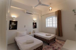 a room with two beds and a window at Mama Africa Apts & Studios in Luxor