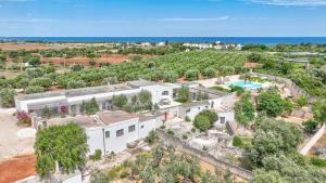 an aerial view of a white building with a pool at Masseria Lamagrotte By Raro Villas in Rosa Marina