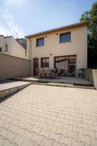 eine Terrasse mit Tisch und Stühlen vor einem Haus in der Unterkunft Les Maisons Bareyre - Grandes Maisons avec terrasse in Saint-Sandoux