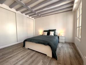 Un dormitorio con una cama grande con dos lámparas encima. en Évasion sur la rivière - 4 pers - Centre, en Moret-sur-Loing 5 fotos más