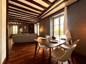 Un comedor con una mesa y sillas y un sofá. en Évasion sur la rivière - 4 pers - Centre, en Moret-sur-Loing