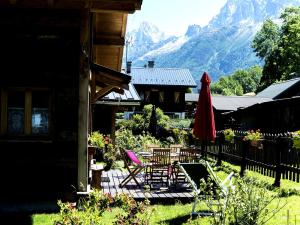 a patio with chairs and a table and an umbrella at Les Chalets du Bonheur in Les Houches