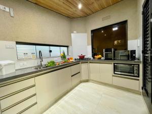 una grande cucina con armadi bianchi e una finestra di Belíssimo Apartamento Stella Maris -Casa de Carrara3 ad Andradina