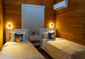 カブレラにあるVilla Dulce Refugioの木製の壁の部屋にベッドが2つある +23枚の写真