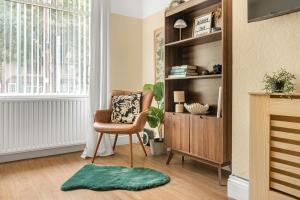 a living room with a chair and a book shelf at 3 Bed House with Home Office Garden and Free Parking in Nottingham