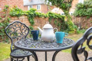 a table with a tea pot and two cups on it at 3 Bed House with Home Office Garden and Free Parking in Nottingham