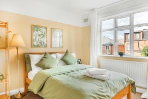 a bedroom with a bed with green sheets and a window at 3 Bed House with Home Office Garden and Free Parking in Nottingham