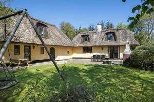 a large yellow house with a thatched roof at JB186-Fjerritslev-Gyvelstien-27 in Torup Strand