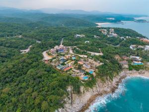 an aerial view of a house on a cliff next to the ocean at 3070 - La Cañada Villa H in Tangolunda