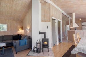 a living room with a couch and a stove at JB293-Fjerritslev-Tyttebaerstien-24 in Torup Strand