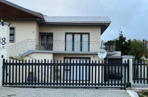 a white house with a black fence in front of it at Aalwynsig in Springbok
