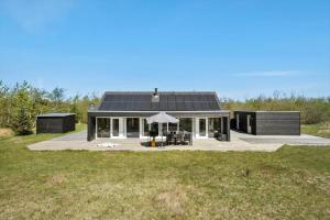 una casa negra con techo solar en un campo en JB214-Brovst-Kronvildtvej-214, en Tranum