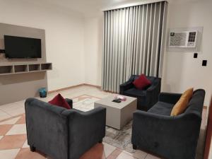 a living room with two couches and a tv at زهرة الضيوف شقق مفروشة in Dammam