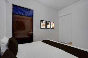 a white bedroom with a bed and a window at SPOT ON RED DIAMOND HOTEL & SWEET RESTAURANT in Phāphāmau