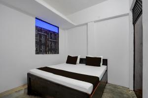 a bed in a white room with a window at SPOT ON RED DIAMOND HOTEL & SWEET RESTAURANT in Phāphāmau