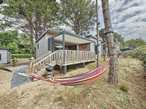 a hammock tied to a tree in front of a house at Cottage Le Béluga in Jullouville-les-Pins