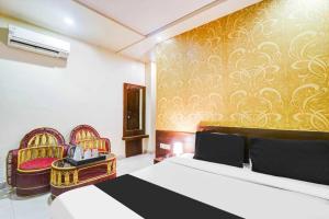 a bedroom with a bed and two chairs at Super Collection O Sindhi Camp Formerly Hotel Abhinandan Inn in Jaipur +27 photos