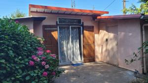 a small house with a wooden door and flowers at maisonnette à la campagne in Saint-Mesmin +1 photo