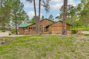 a log cabin in the woods with trees at Hot Tub and Deck Home 1 Mi to Ruidoso River! in Ruidoso