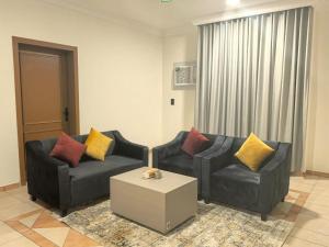 a living room with two couches and a coffee table at زهرة الضيوف شقق مفروشة in Dammam +1 photo