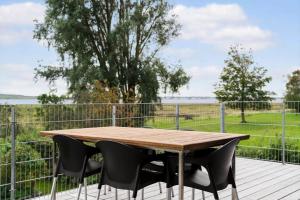 a wooden table and chairs on a deck with a fence at JB244-Logstor-Aggersborgvej-51 in Løgstør