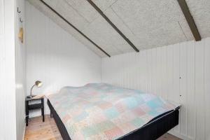 a bedroom with a bed and a lamp on a table at JB273-Fjerritslev-Hasselvej-39 in Fjerritslev