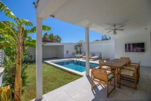 a patio with a table and chairs and a swimming pool at Traditional Seaside Stone Villa with Private Pool in Bodrum City