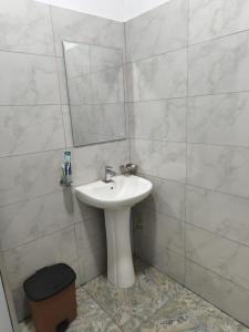 een badkamer met een wastafel en een spiegel bij TN Travel Inn - Katunayake in Katunayaka +22 foto's