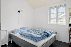 ein Bett mit blauer Decke in einem Schlafzimmer in der Unterkunft JB175-23 Brovst - Kronvildtvej 60 in Tranum