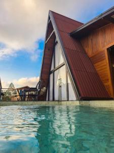 una casa con techo rojo y piscina en Gran Chalé, en Santa Teresa