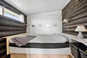 a bed in a room with a wooden wall at JB119-Brovst-Ejstrup-Strandvej-18 in Brovst