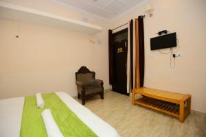 a bedroom with a bed and a chair and a tv at Ds Royal Inn in Malhour