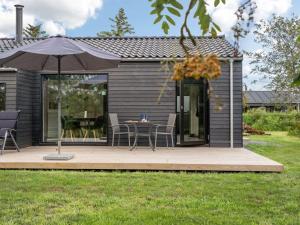 una piccola casa con tavolo e ombrellone di Holiday Home Hildegard - 1-5km from the sea by Interhome a Hjørring