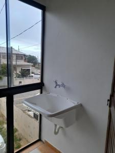 a white sink in a room with a window at Studio Duplex Praia do Porto in Imbituba