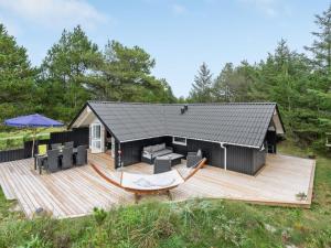 a house with a large deck with a table at Holiday Home Varpu - 1-6km from the sea by Interhome in Saltum
