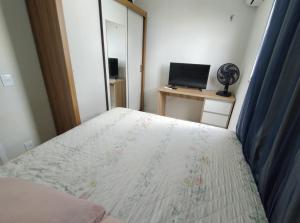 a bedroom with a bed and a desk with a computer at Apartamento in Ananindeua