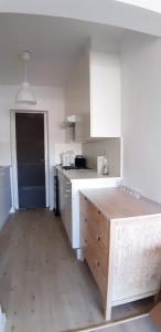 Una cocina con gabinetes blancos y una encimera de madera. en Miss Cato, en Ostende