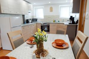 a kitchen with a table with a vase of flowers on it at Chata penzion Zuberec in Zuberec