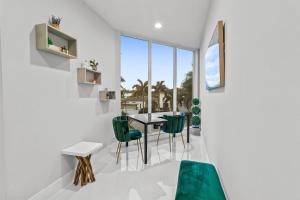 a dining room with a table and green chairs at Brand new Luxurious Villa in Hollywood Beach +86 photos