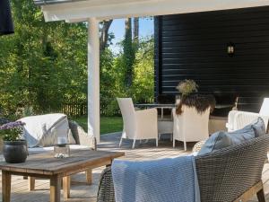 a patio with wicker chairs and a wooden table at Holiday Home Anar - 900m from the sea by Interhome in Græsted