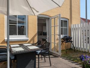 a patio with a table and chairs and an umbrella at Apartment Cornel - 290m from the sea by Interhome in Hjørring +8 photos