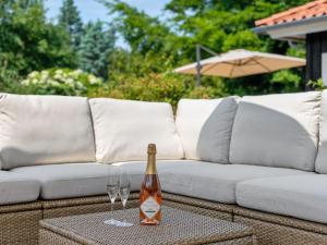 a bottle of wine sitting on a table with two wine glasses at Holiday Home Elline - 450m from the sea by Interhome in Græsted