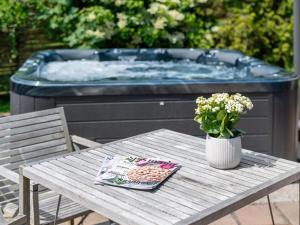 a picnic table with a tub and a vase of flowers at Holiday Home Elline - 450m from the sea by Interhome in Græsted +16 photos