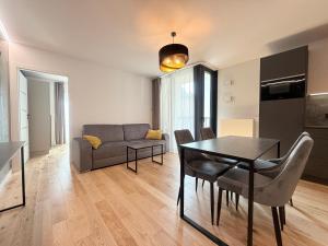 ein Wohnzimmer mit Tisch und Couch in der Unterkunft Boulevard Vistula Apartment Swimming Pool, Sauna, Gym & Parking in Krakau