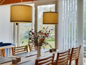 a dining room table with a vase of flowers and lights at Holiday Home Norna - 300m from the sea by Interhome in Store Fuglede +13 photos