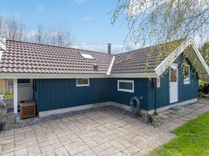 a blue house with a patio in front of it at Holiday Home Norna - 300m from the sea by Interhome in Store Fuglede